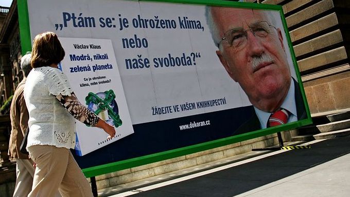 Naproti kavárně Slávia - hned vedle Národního divadla stoji provizorní billboard s reklamou na prezidentovu knihu.