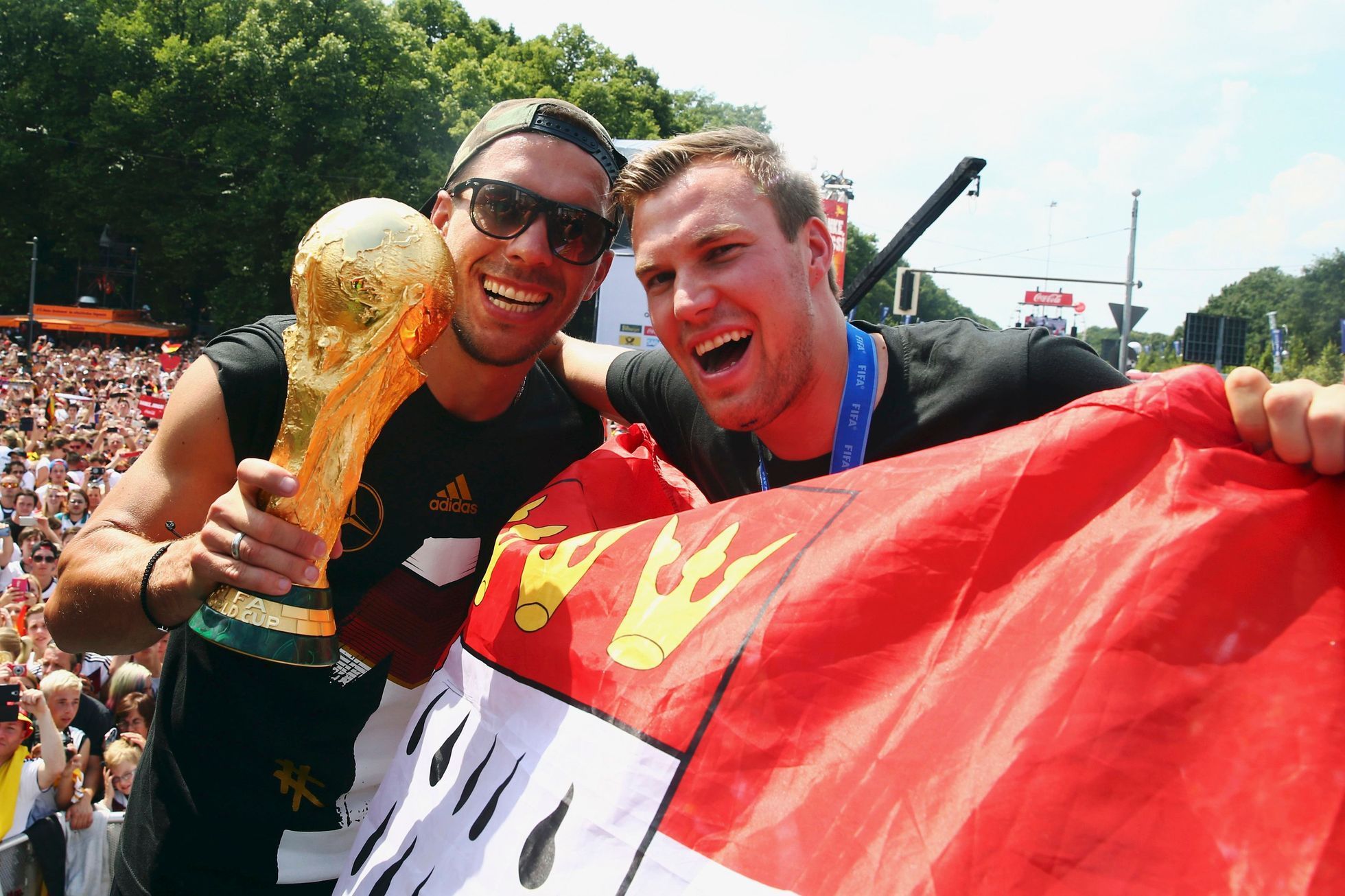Lukas Podolski a Kevin Grosskreutz slaví s fanoušky titul z MS 2014