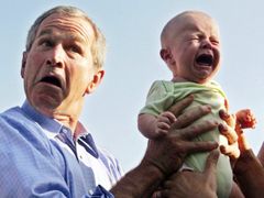 Americký prezident George W. Bush odkládá plačící dítě, které mu podal někdo z davu příznivců během jeho červencové návštěvy u německé kancléřky Angely Merkelové v Trinwillershagenu.