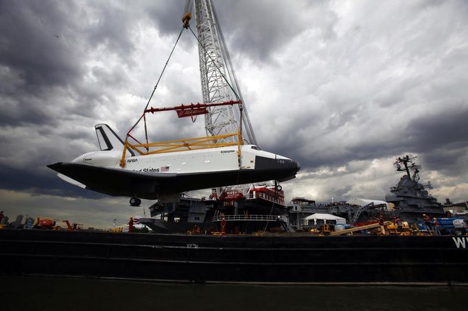 Crews hoist the Space Shuttle Enterprise onto the deck of the Intrepid Sea, Air and Space Museum in New York June 6, 2012. REUTERS/Eric Thayer (UNITED STATES - Tags: SOCIETY TRANSPORT) Published: Čer. 7, 2012, 12:13 dop.