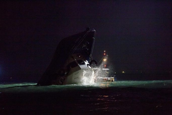 Rescuers approach a partially-submerged boat after two vessels collided in Hong Kong October 1, 2012. A major rescue is underway in the waters near Yung Shue Wan on Hong Kong's Lamma island following a collision involving two vessels in the evening, government radio reported on Monday. Police say there were about 100 people onboard both vessels, with many of them in the water. The government says 101 people have been rescued so far with at least 25 hospitalised. REUTERS/Tyrone Siu (CHINA - Tags: DISASTER TRANSPORT) Published: Říj. 1, 2012, 6:18 odp.