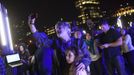 People watch as magician David Blaine channels bolts of electricity from various tesla coils charged with one million volts of electricity during a stunt on Pier 54 in New York, October 5, 2012. Blaine hopes to stand in the same position for 72 hours. REUTERS/Andrew Burton (UNITED STATES - Tags: SOCIETY ENTERTAINMENT) Published: Říj. 6, 2012, 4:06 dop.