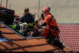 Záchranář se speciální výbavou vyráží na střechu.