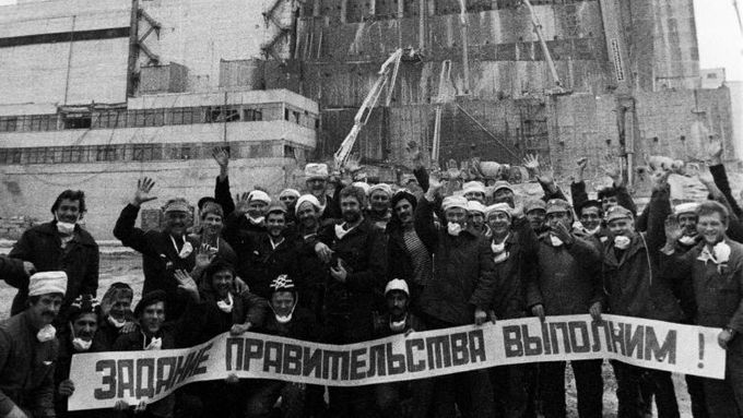 Ti, kteří nasazovali životy. Dělníci, kteří zakonzervovávali Černobyl, třímají v listopadu 1986 transparent hlásající, že úkol vlády bude splněn.