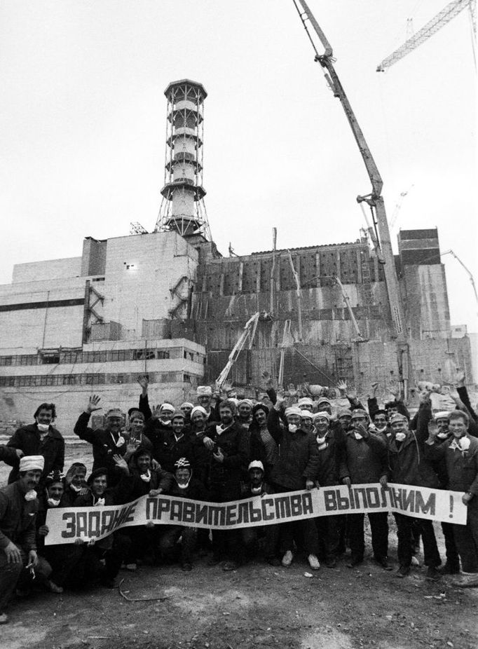 Ti, kteří nasazovali životy. Dělníci, kteří zakonzervovávali Černobyl, třímají v listopadu 1986 transparent hlásající, že úkol vlády bude splněn.