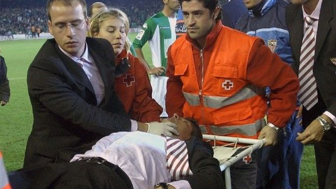 Kouč FC Sevilla je odnášen na nosítkách poté, co ho zasáhl do hlavy předmět hozený diváky zápasu španělského poháru s městským rivalem Realem Betis.