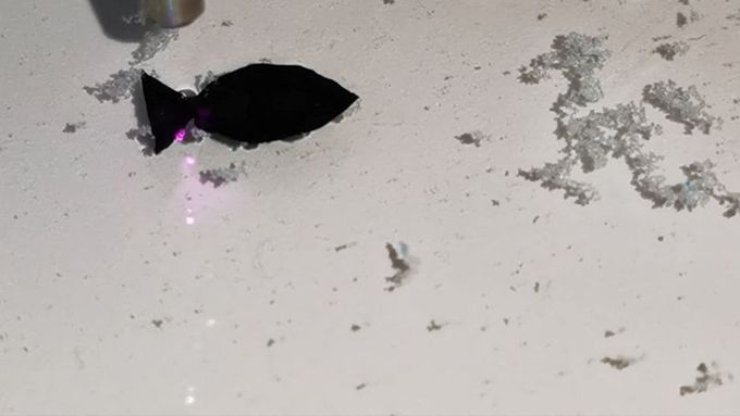 Černá robotická ryba reaguje na světlo, které jí pomáhá při pohybu.