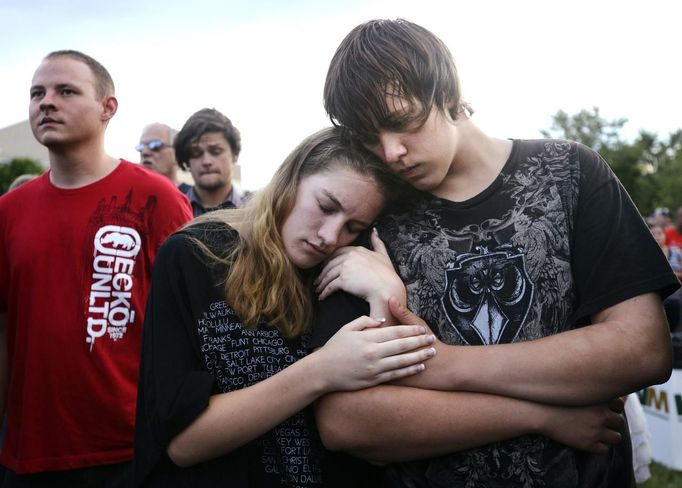 Tanner Coon (R) and his friend Shelby Herbert hold each other tightly at the Aurora Municipal Center during a vigil for the victims killed in last Friday's Century 16 movie theater in Aurora, Colorado July 22, 2012. Coon was in theater 9 during the shooting and escaped with two other friends. Residents of a Denver suburb mourned their dead on Sunday from a shooting rampage by a gunman who killed 12 people and wounded 58 after opening fire at a cinema showing the new Batman movie. REUTERS/Jeremy Papasso (UNITED STATES - Tags: CRIME LAW CIVIL UNREST OBITUARY TPX IMAGES OF THE DAY) Published: Čec. 23, 2012, 2:08 dop.