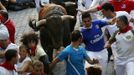 Runners sprint alongside Victoriano del Rio fighting bulls at the entrance to the bullring during the sixth running of the bulls of the San Fermin festival in Pamplona July 12, 2012. Several runners suffered light injuries in the fastest run (two minutes and twenty seconds) so far in this festival, according to local media. REUTERS/Susana Vera (SPAIN - Tags: ANIMALS SOCIETY) Published: Čec. 12, 2012, 8:25 dop.