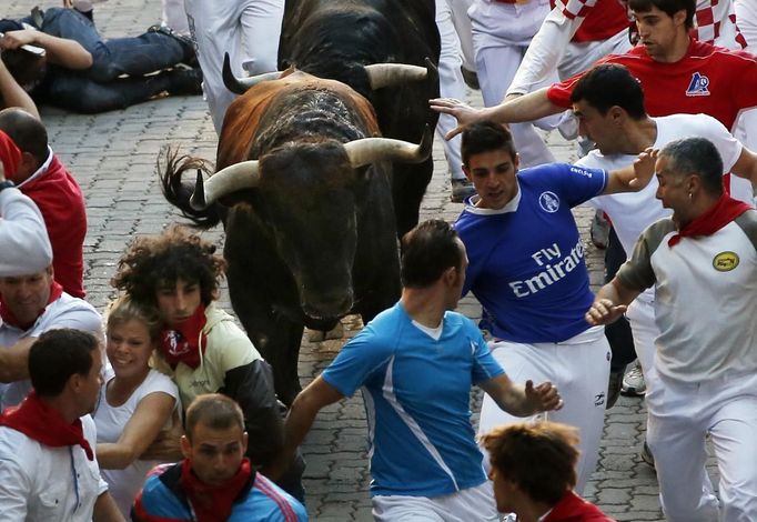 Runners sprint alongside Victoriano del Rio fighting bulls at the entrance to the bullring during the sixth running of the bulls of the San Fermin festival in Pamplona July 12, 2012. Several runners suffered light injuries in the fastest run (two minutes and twenty seconds) so far in this festival, according to local media. REUTERS/Susana Vera (SPAIN - Tags: ANIMALS SOCIETY) Published: Čec. 12, 2012, 8:25 dop.