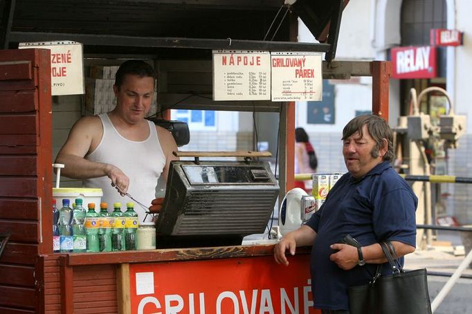 Pán v nátělníků prodává párky z lávového grilu na nádraží už patnáct let.