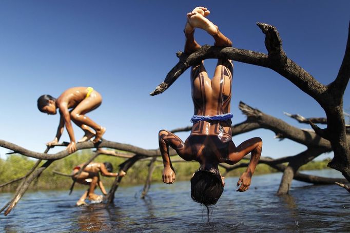 Yawalapiti children play over the Xingu River in the Xingu National Park, Mato Grosso State, May 9, 2012. In August the Yawalapiti tribe will hold the Quarup, which is a ritual held over several days to honour in death a person of great importance to them. This year the Quarup will be honouring two people - a Yawalapiti Indian who they consider a great leader, and Darcy Ribeiro, a well-known author, anthropologist and politician known for focusing on the relationship between native peoples and education in Brazil. Picture taken May 9, 2012. REUTERS/Ueslei Marcelino (BRAZIL - Tags: ENVIRONMENT SOCIETY) ATTENTION EDITORS - PICTURE 16 OF 28 FOR PACKAGE 'LIFE WITH THE YAWALAPITI TRIBE' TEMPLATE OUT Published: Kvě. 15, 2012, 5:10 odp.