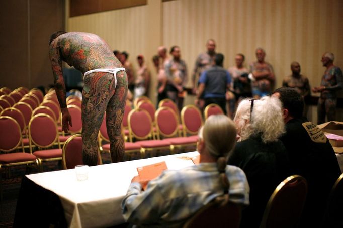 Contestant Yoshi shows off the back of his full-body tattoo to the judges at the National Tattoo Association Convention in Cincinnati, Ohio April 13, 2012. Yoshi, from Japan, was tattooed by Horiyoshi III and is a multi-award winning contestant in the world of full-body tattoos. In Cincinnati he won third place in the 'Best Tattooed Male' category. Picture taken April 13, 2012. REUTERS/Jason Reed (UNITED STATES - Tags: SOCIETY) ATTENTION EDITORS PICTURE 27 OF 31 FOR PACKAGE 'ADDICTED TO THE NEEDLE' TO FIND ALL PICTURES SEARCH 'ADDICTED NEEDLE' Published: Čer. 29, 2012, 1 odp.