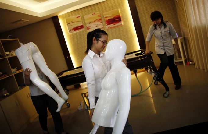 Students carry pieces of a plastic mannequin during their undertaker service class at the Tianquanjiajing Funeral Service school in Jiaxing, Zhejiang province May 29, 2012. A new breed of young Chinese undertakers are fighting centuries-old taboos to gain social acceptance for their profession, saying they help the deceased and their families make their final parting with respect. There are more than 1,500 students across the country studying to become undertakers each year. Courses in funeral services take three years to complete and the service includes washing of the dead body as well as providing funeral make-up and dressing. Picture taken may 29, 2012. REUTERS/Carlos Barria (CHINA - Tags: SOCIETY) ATTENTION EDITORS - PICTURE 11 OF 17 FOR PACKAGE 'FUNERAL SERVICE STUDENTS' Published: Čer. 7, 2012, 2:44 dop