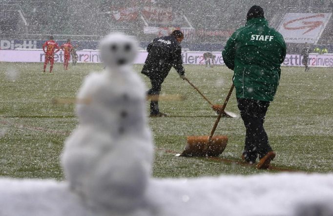 A snowman is pictured as ground staff remove snow from the pitch during their Swiss Super League soccer match FC St. Gallen against FC Thun in St. Gallen in St. Gallen October 28, 2012. REUTERS/Miro Kuzmanovic (SWITZERLAND - Tags: SPORT SOCCER) Published: Říj. 28, 2012, 3:50 odp.