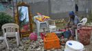 A Haitian woman whose house was flooded due to Tropical Storm Isaac sits with the items she was able to salvage, in an area outside of Port-au-Prince August 26, 2012. Tropical Storm Isaac left six dead in Haiti, still recovering from a 2010 earthquake, and at least three missing in the Dominican Republic after battering their shared island of Hispaniola on Saturday. REUTERS/Swoan Parker (HAITI - Tags: DISASTER POLITICS) Published: Srp. 26, 2012, 6:11 odp.