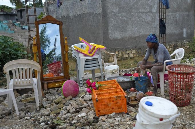 A Haitian woman whose house was flooded due to Tropical Storm Isaac sits with the items she was able to salvage, in an area outside of Port-au-Prince August 26, 2012. Tropical Storm Isaac left six dead in Haiti, still recovering from a 2010 earthquake, and at least three missing in the Dominican Republic after battering their shared island of Hispaniola on Saturday. REUTERS/Swoan Parker (HAITI - Tags: DISASTER POLITICS) Published: Srp. 26, 2012, 6:11 odp.