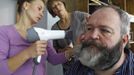 German hairdresser Elmar Weisser (R), 48, is helped by his wife Monica (C) and his friend Jessica as they start shaping his beard as a stork to compete in the 2012 European Beard and Moustache Championships in Wittersdorf near Mulhouse, Eastern France, September 22, 2012. Weisser, who won the World Beard and Moustache Championship in 2011, ranked second in the freestyle category of the European championships on Saturday. Picture taken September 22, 2012. REUTERS/Vincent Kessler (FRANCE - Tags: SOCIETY) Published: Zář. 23, 2012, 11:49 dop.