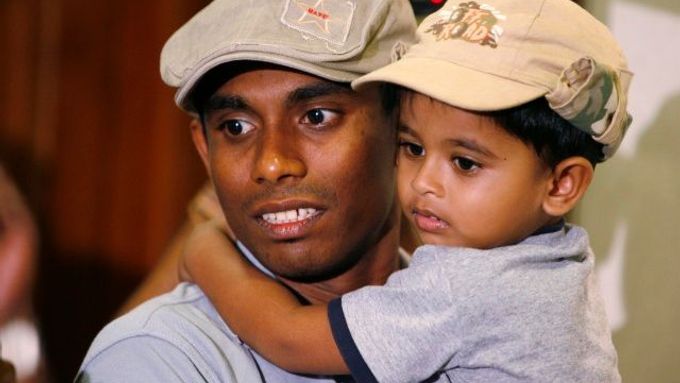 Thilan Thushara drží svého syna po příletu na letiště v Kolombu