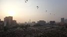 Military helicopters are seen flying over while people gather at Tahrir Square in Cairo