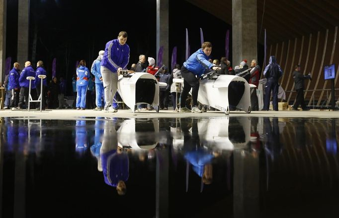 Russian servicemen prepare the bobsleighs for the two-women's bobsleigh competition during the test event at the "Sanki" siding center in Rosa Khutor, a venue for the Sochi 2014 Winter Olympics near Sochi February 15, 2013. The Sochi 2014 Winter Olympics opens on February 7, 2014. REUTERS/Kai Pfaffenbach (RUSSIA - Tags: SPORT OLYMPICS) Published: Úno. 15, 2013, 5:12 odp.