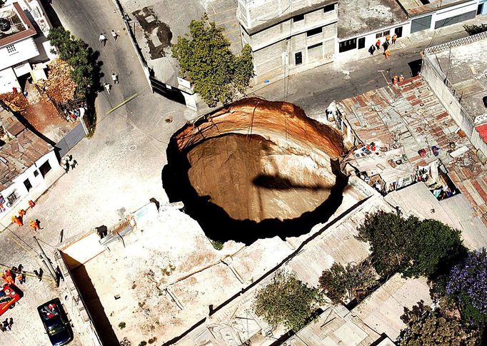 Giant sink hole in Guatemala City 2007-02-23 00:00:00 epa00940357 Overview of a giant sinkhole, 150 metres deep and 20 metres wide, in the neighbourhood of San Antonio in Guatemala City, Friday 23 February 2007, The sink hole swallowed close to twenty homes and left three people missing. EPA/ULISES RODRIGUEZ