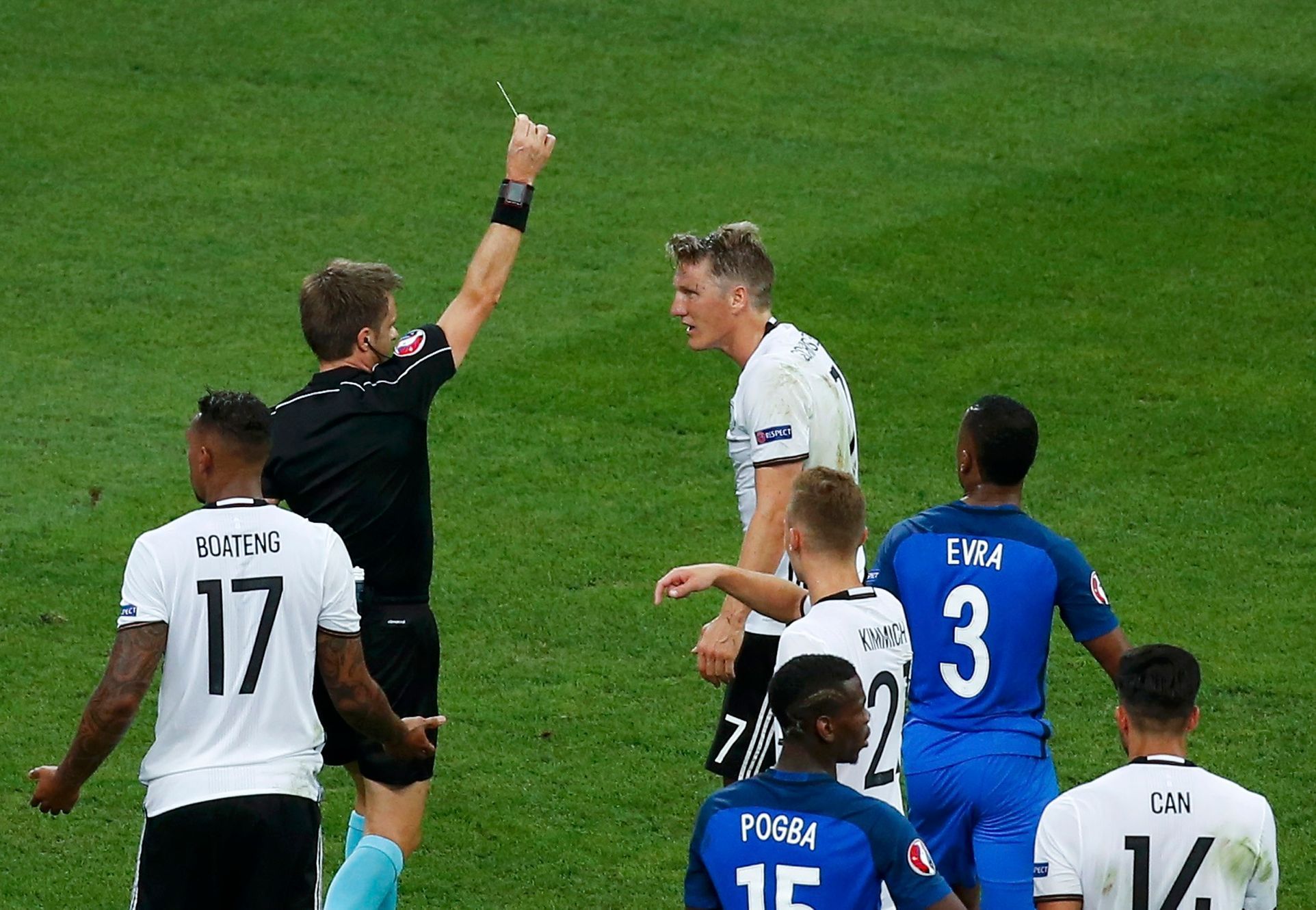 ME 2016, Francie-Německo: Bastian Schweinsteiger dostává od rozhodčího Nicolya Rizzoliho žlutrou kartu za penaltovou ruku