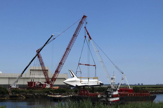 The Space Shuttle Enterprise waits to be lifted onto a barge at John F. Kennedy International Airport's harbor for a four-day journey to the Intrepid Sea, Air & Space Museum in New York June 2, 2012. REUTERS/Eduardo Munoz (UNITED STATES - Tags: SCIENCE TECHNOLOGY TRANSPORT) Published: Čer. 2, 2012, 10:30 odp.