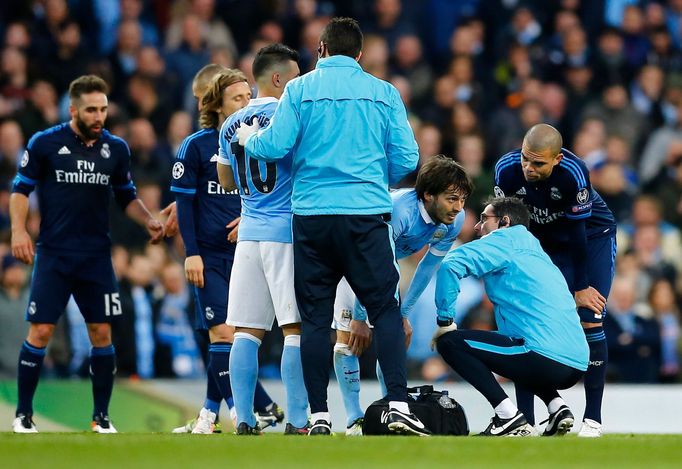 Manchester City's David Silva receives treatment after sustaining an injury as Real Madrid's Pepe looks on