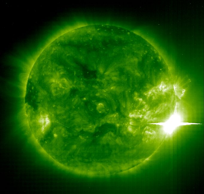 This is an image of the extremely powerful solar flare on November 4, 2003, taken by the SOHO spacecraft. The image reveals hot gas in the solar atmosphere in false color, and the flare is the bright, white area on the right edge of the sun. The horizontal line through the flare is not real; it's just the result of the flare's intense light saturating the detector in the instrument making the image: SOHO's Extreme-ultraviolet Imaging Telescope. Credit: The European Space Agency and NASA.