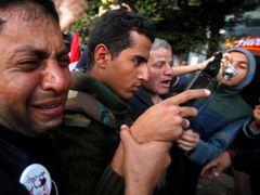 Plačící demonstrant na centrálním náměství v Káhiře drží za ruku mladého vojáka poté, co armádní velitel protestujícím slíbil, že jejich požadavky budou vyslyšeny