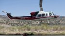 A helicopter scoops water from a river as fire fighters battle the Topaz Ranch Estates fire in Wellington, Nevada May 24, 2012. Lighter winds and higher humidity helped crews' efforts to curb the Topaz Ranch Estates wildfire that has razed more than 9 square miles (23 square km) of brush south of Carson City, charring two homes and more than a dozen outbuildings. REUTERS/James Glover II (UNITED STATES - Tags: DISASTER ENVIRONMENT) Published: Kvě. 25, 2012, 1:52 dop.