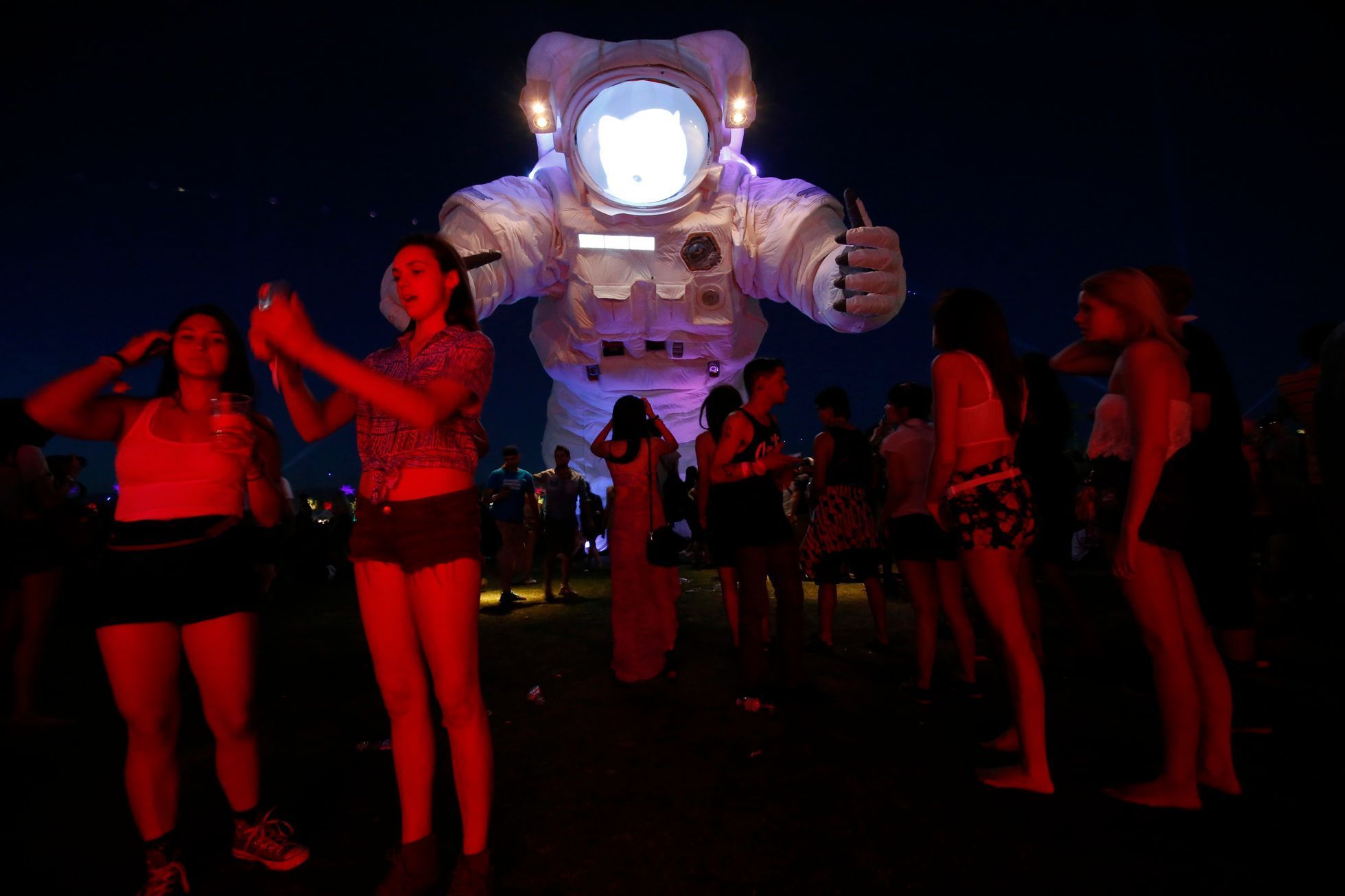 People stand in front of a large-scale moving sculpture called &quot;Escape Velocity&quot; by Poetic Kinetics at Coachella Valley Music and Arts Festival in Indio, California