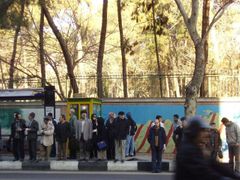 Lidé čekají před budovou bývalého amerického velvyslanectví v Teheránu na autobus