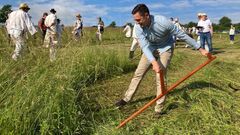 Hejtman Jihomoravského kraje Jan Grolich při sečení trávy na folklorní akci v Malé Vrbce.