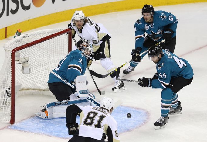 Pittsburgh - San Jose. Carl Hagelin (PIT) číhá u tyče. Martin Jones se klouže v brankovišti. Jastin Braun a Marc-Eduard Vlasic přihlíží. A Phil Kessel očekává puk