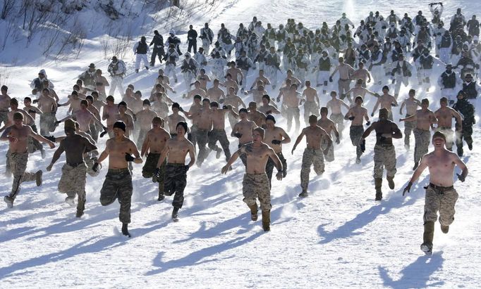 South Korean and U.S. marines run during a winter military drill in Pyeongchang, about 180 km (112 miles) east of Seoul February 7, 2013. North Korea has vowed to conduct more rocket and nuclear tests in response to a U.N. censure for its launch of a long-range missile launch in December. On Tuesday, it vowed "stronger" but unspecified actions in addition to the test. REUTERS/Lee Jae-Won (SOUTH KOREA - Tags: MILITARY TPX IMAGES OF THE DAY) Published: Úno. 7, 2013, 7:47 dop.