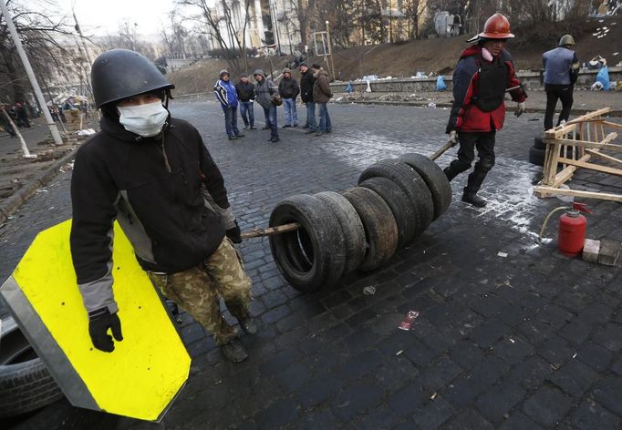 Anti-government protesters carry tyres to a barricade in Kiev February 21, 2014.