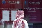 Muž si pročítá nápis na dveřích Qatar Airways.