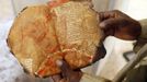 A museum guard displays a burnt ancient manuscript at the Ahmed Baba Institute, or Ahmed Baba Centre for Documentation and Research, in Timbuktu January 31, 2013. The majority of Timbuktu's ancient manuscripts appear to be safe and undamaged after the Saharan city's 10-month occupation by Islamist rebel fighters, experts said on Wednesday, rejecting some media reports of their widespread destruction. REUTERS/Benoit Tessier (MALI - Tags: POLITICS CIVIL UNREST CONFLICT SOCIETY TPX IMAGES OF THE DAY) Published: Led. 31, 2013, 6:53 odp.