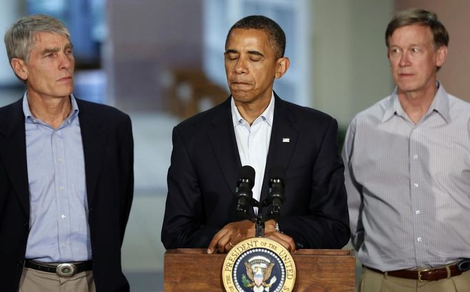 U.S. President Barack Obama (C) pauses while speaking at the University of Colorado Hospital after he met with families bereaved after a gunman went on a shooting rampage at a movie theater in Aurora, Colorado July 22, 2012. Standing beside Obama are U.S. Senator Mark Udall (L) and Colorado Governor John Hickenlooper (R). Obama headed to Aurora, Colorado, on Sunday to meet families grieving their losses Friday's mass shooting that has stunned the nation and rekindled debate about guns and violence in America. REUTERS/Larry Downing (UNITED STATES - Tags: POLITICS CRIME LAW) Published: Čec. 23, 2012, 1:16 dop.