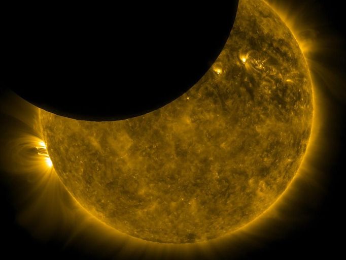 Sun and Moon On Oct. 7, 2010, NASA's Solar Dynamics Observatory, or SDO, observed its first lunar transit when the new moon passed directly between the spacecraft (in its geosynchronous orbit) and the sun. With SDO watching the sun in a wavelength of extreme ultraviolet light, the dark moon created a partial eclipse of the sun. Image Credit: NASA