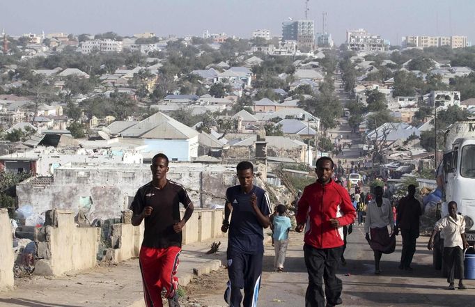 Somali athletes run along a street as they train during preparations for the 2012 London Olympic Games in Somalia's capital Mogadishu, in this March 14, 2012 file photo. Training in a bullet-riddled stadium where the remains of a rocket propelled grenade lies discarded on the track's edge counts as progress for Somali Olympic hopeful Mohamed Hassan Mohamed. A year ago, Mogadishu's Konis stadium was a base for Islamist militants and a work out meant at times running through the streets, dodging gun-fire and mortar shells in one of the world's most dangerous cities. To match OLY-SOMALIA-HOPES/ REUTERS/Feisal Omar/Files (SOMALIA - Tags: SPORT ATHLETICS SOCIETY OLYMPICS) Published: Čer. 11, 2012, 7:03 dop.