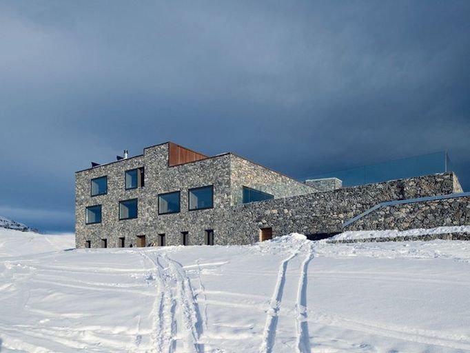 Přeměna restaurace Chetzeron, actescollectifs architectes sa, Crans-Montana (Valais), 2008-2009 Objekt se nachází ve výšce 2 100 metrů a skládá se z restaurace a bývalé stanice kabinové lanovky.  V severní části stavby se nachází v okolí krbu lounge s barem a na jihu je hlavní místnost restaurace s kaskádovitými terasami s nádherným výhledem na hřeben Walliských Alp.