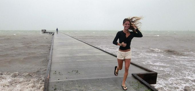 An unidentified woman leaves the pier in high wind and rough surf as Tropical Storm Isaac moves over the island August 26, 2012. Tropical Storm Isaac lashed south Florida with winds and heavy rain on Sunday after battering the Caribbean, disrupting plans for the Republican National Convention in Tampa and threatening to interrupt about half of U.S. offshore oil output. REUTERS/Andrew Innerarity (UNITED STATES - Tags: ENVIRONMENT DISASTER TPX IMAGES OF THE DAY) Published: Srp. 27, 2012, 6:42 dop.