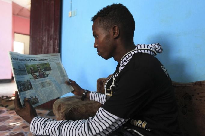 Somali athlete Abdullah Bare Kuulow reads the newspapers after a training session during their preparations for the 2012 London Olympic Games in Somalia's capital Mogadishu in this March 14, 2012 file photo. Training in a bullet-riddled stadium where the remains of a rocket propelled grenade lies discarded on the track's edge counts as progress for Somali Olympic hopeful Mohamed Hassan Mohamed. A year ago, Mogadishu's Konis stadium was a base for Islamist militants and a work out meant at times running through the streets, dodging gun-fire and mortar shells in one of the world's most dangerous cities. To match OLY-SOMALIA-HOPES/ REUTERS/Feisal Omar/Files (SOMALIA - Tags: SPORT ATHLETICS SOCIETY OLYMPICS) Published: Čer. 11, 2012, 6:41 dop.