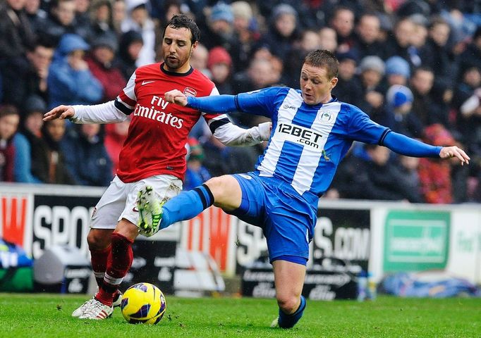 James McCarthy z Wiganu (vpravo) atakuje křídelníka Arsenalu Santi Cazorlu.