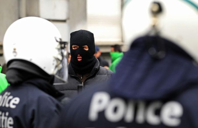 An Arcelor Mittal worker from Liege looks at riot police during a demonstration outside Prime Minister Elio Di Rupo's office, where a political meeting is taking place, in Brussels January 25, 2013. ArcelorMittal the world's largest steel producer, plans to shut a coke plant and six fininishing lines at its site in Liege Belgium, affecting 1,300 employees, the group said on Thursday. REUTERS/Yves Herman (BELGIUM - Tags: BUSINESS CIVIL UNREST EMPLOYMENT) Published: Led. 25, 2013, 12:38 odp.