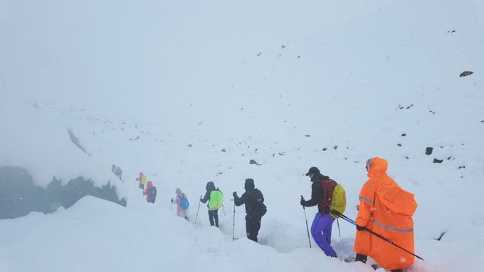 Turisté opouštějící svůj tábor za neobvykle silného sněžení a deště bičujícího Himálaj v Tibetu, 5. října 2025 (výstřižek z videa).