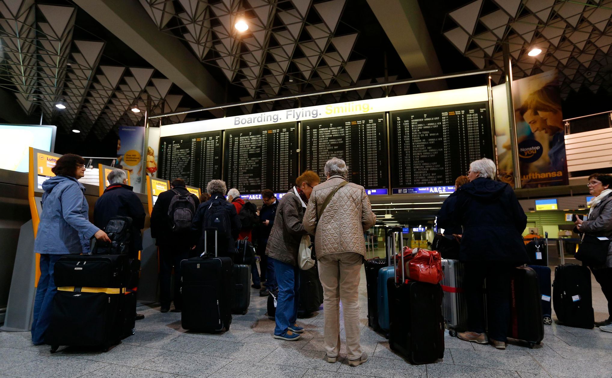 Passengers wait in front of check-in machines of German air carrier Lufthansa at Fraport airport in Frankfurt
